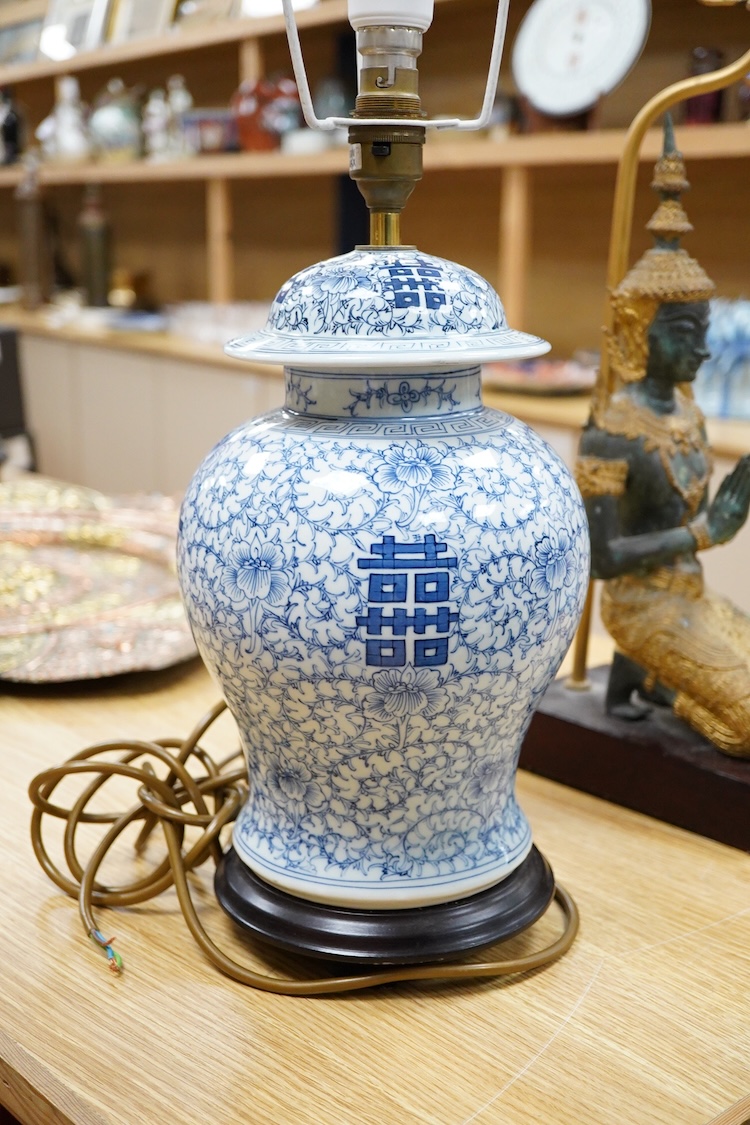 A Chinese blue and white ‘shuangxi’ vase and cover, mounted as a lamp, together with a lamp mounted with a bronze Thai figure, largest 50cm high including light fitting
